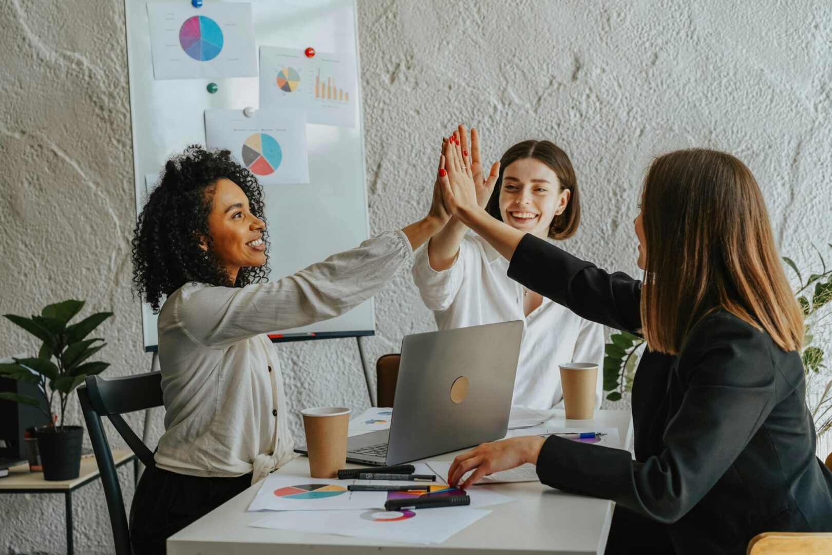 Three women giving each other a high five.